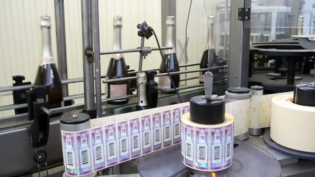 Machine applying excise stamps for wine products at a distillery