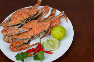 Crabs closeup with Thai seafood dipping sauce on a plate, on a wooden background