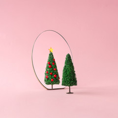 Christmas tree with mirror on pastel pink background. Minimal New Year decoration concept.
