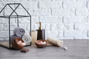 Soap with rolled towels on grey table in bathroom