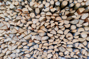 Large pile or stock of firewood for heating furnace. Logs and logs of birch. The log is split in half. Slice as a circle or semicircle. Background, backdrop or texture.