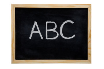 Fototapeta premium WOODEN FRAMED BLACK BOARD WITH THE LETTERS A B C WRITTEN WITH WHITE CHALK