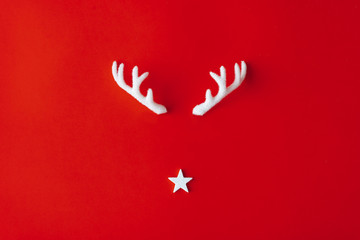 Reindeer antlers with star on red background. Christmas minimal Greeting card.