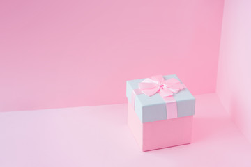 Close view minimal composition of pink Christmas gift box on pastel backdrop. New Year present concept background.