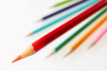 BRIGHT RED COLOURED PENCIL WITH OTHER PENCILS IN BACKGROUND