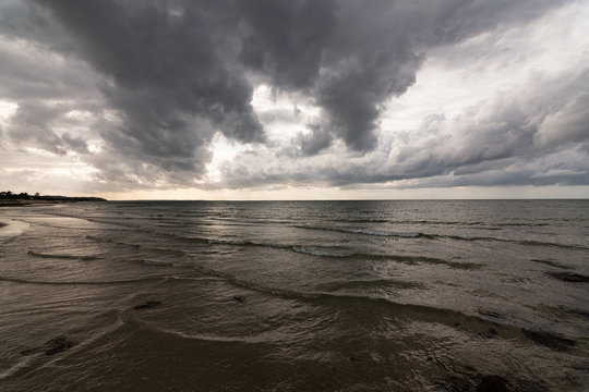 Dark clouds over calm water at the ocean