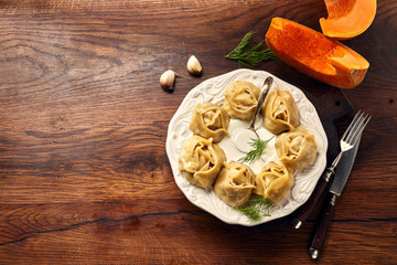 Asian steamed dumplings Manti with pumpkin and garlic. Top view and copy space.