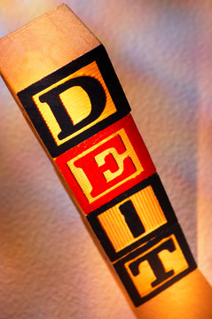 STACK OF WOODEN TOY BUILDING BLOCKS WITH LETTERS SPELLING THE WORD DEIT