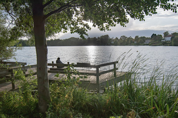 Old man fishing at lake