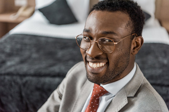 smiling african american businessman in eyeglasses and formal wear