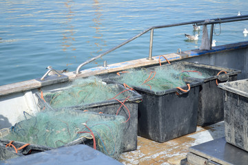 Fishing nets are in containers on the deck of a fishing vessel