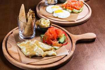 Omelette with vegetables and bread on wooden table in the restaurant. Tasty food. Gourmet