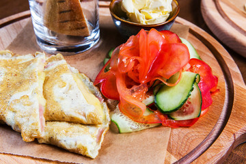 Omelette with vegetables and bread on wooden table in the restaurant. Tasty food. Gourmet