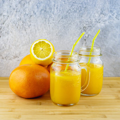Obraz na płótnie Canvas glass of juice and lemons on wooden table