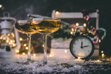 Image of two wine glasses on blurred background with Christmas tree, lantern, clock