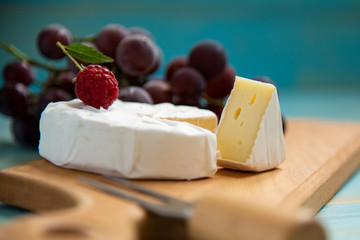 cheese camembert with raspberries and grapes on