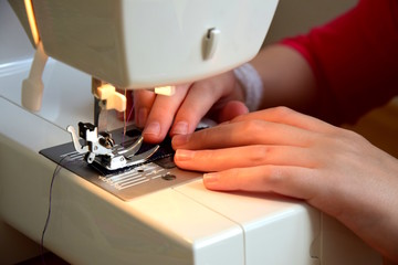 Junges Mädchen näht mit ihrer Nähmaschine 