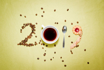 Year 2019 numbers made of coffee beans, cup od coffee, spoon and cookies. New year concept.