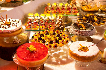 Obrazy na Szkle  Swiąteczny stół zastawiony kolorowymi ciastami i ciasteczkami