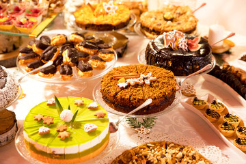 Fototapeta na wymiar Swiąteczny stół zastawiony kolorowymi ciastami i ciasteczkami