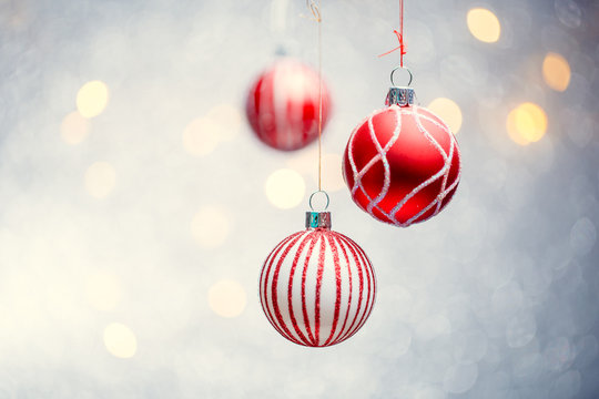 Photo of three Christmas red balls on gray background with spots.