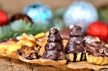 Close-up of christmas sweets with different types of candy on baking paper and Christmas decorations