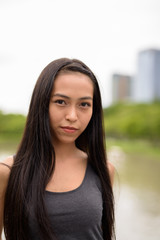 Young beautiful Asian woman relaxing at the park