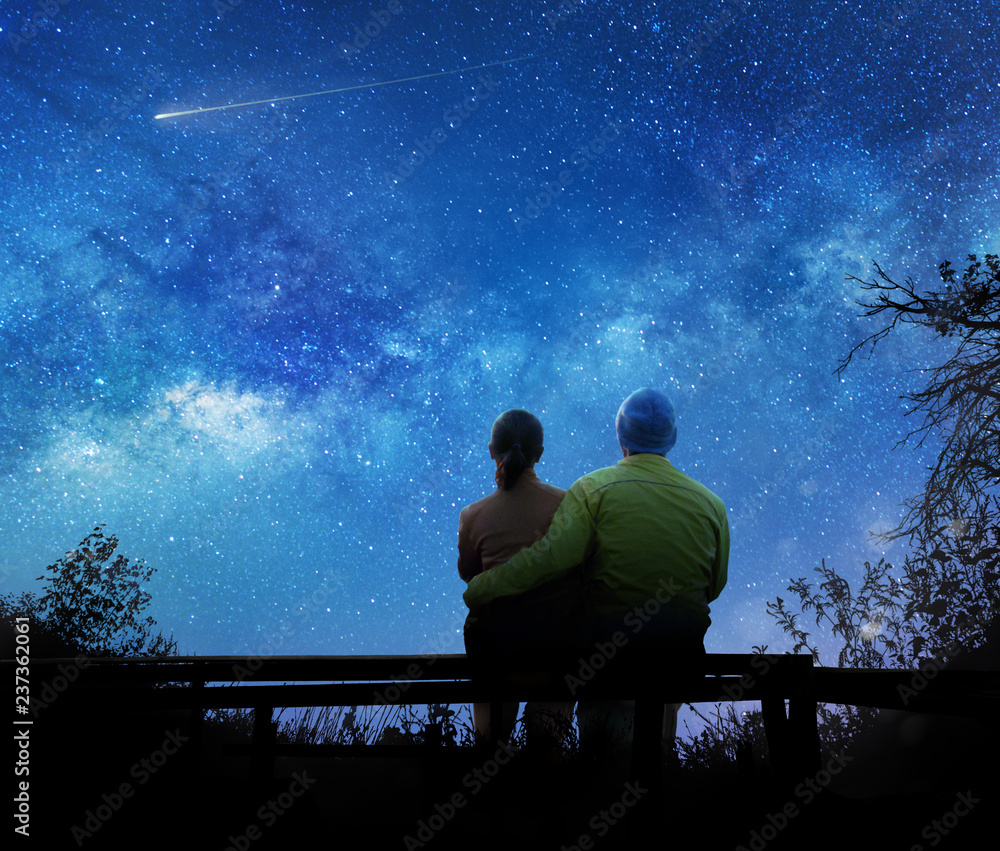 Wall mural couple watching the stars in night sky