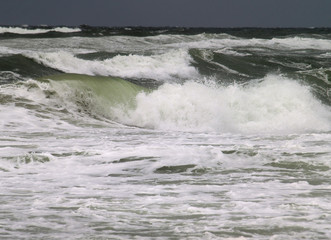 große Wellen am Strand von Kampen/Sylt, vor einem dunklen Himmel
