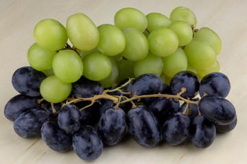 Green and Black Grapes on a Wooden Table