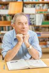 Happy senior man in the library