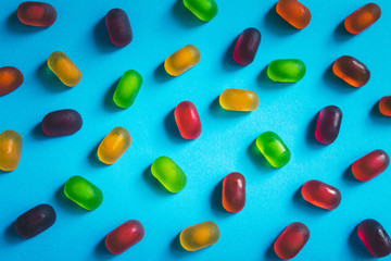 Multicolored gummy candies pattern on a blue background