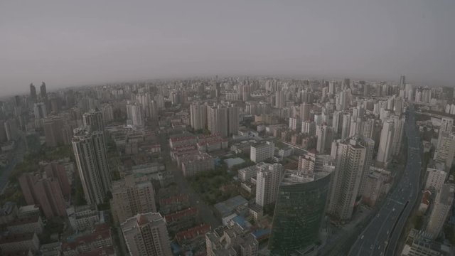 Shanghai cityscape buildings until the horizon. Endless urban sprawl as far as the eye can see in China. Typical part of the city with countless apartments and office buildings and highway with cars.