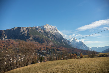Traveling. A beautiful landscape. Alpine mountains, forest and yellow field.