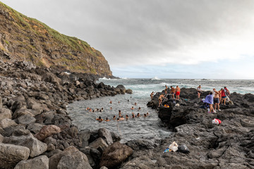 GINETES, PORTUGAL - AUGUST 3: Unidentified people bath in the ocean hotsprings at the Piscina Natural da Ponta da Ferraria near Ginetes, Portugal on August 3, 2017.