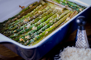 Green juicy asparagus is in ceramic form in olive oil
