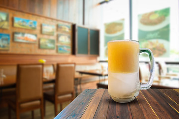 Beer on wooden table in bar and space text.