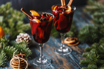 Christmas hot mulled wine in a glass with spices, citrus fruit and cranberry. Christmas atmosphere. 