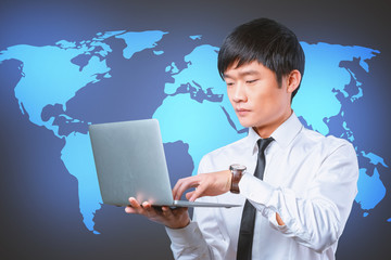 young smiling asian businessman holding laptop