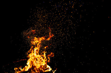 Burning woods with firesparks, flame and smoke. Strange weird odd elemental fiery figures on black background. Coal and ash. Abstract shapes at night. Bonfire outdoor on nature. Strenght of element.