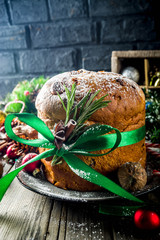 Traditional Christmas panettone with dried fruits and nuts, on old wooden background wth christmas decoration copy space top view