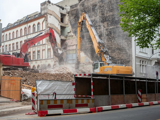 Fototapeta na wymiar Digger demolishing houses for reconstruction