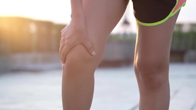 Knee pain .woman sitting on the bed  Her hand caught at the knee. Having painful feet and stretching muscles fatigue To relieve pain. health concepts.