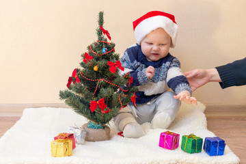 Mom holds the hand of a disgruntled kid in a Santa hat