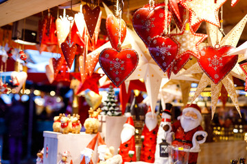 Different decoration, toy for xmas tree on christmas market, close up of cozy handmade hearts - obrazy, fototapety, plakaty