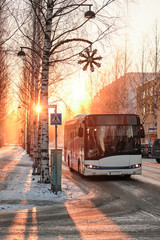 Bus on the street in winter on the background  of sunset