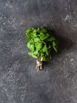 A bunch of fresh green fragrant mint  on a dark gray background. Top view. Copy space
