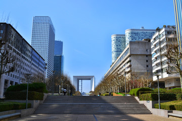 View of the promenade in the district of La Defense in Paris. Modern skyscrapers, blue sky, stairs.
