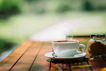 Hot coffee latte cappuccino spiral foam on wooden table in coffee shop cafe with vintage color tone filter background. With copy space for your text.