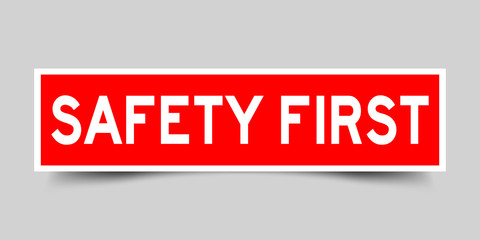 Red color label sticker in word safety first on gray background
